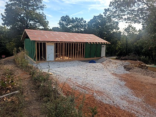 Gravel drive and framed house with roof decking