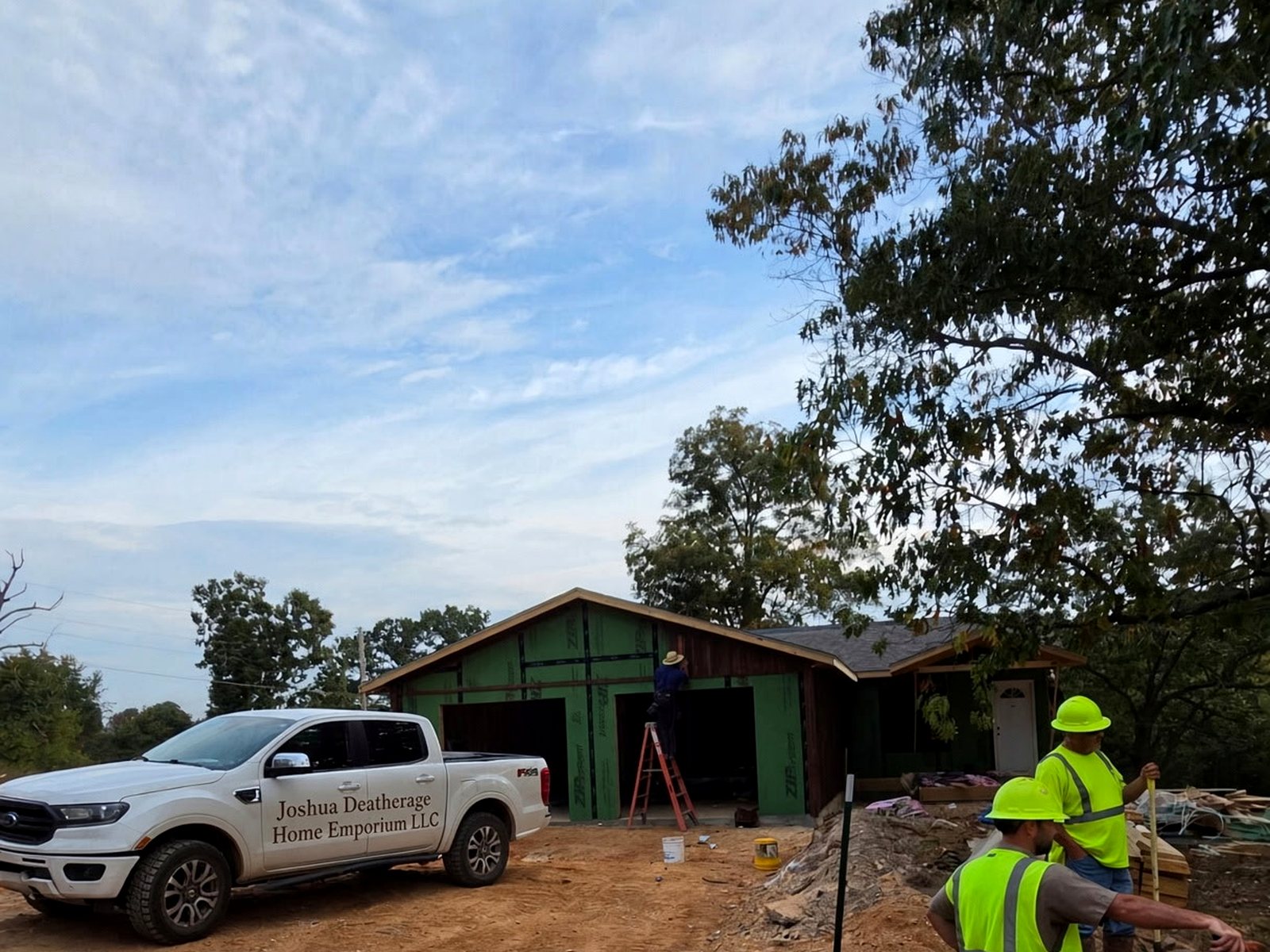 Crew working the drive, with the company truck parked at the house
