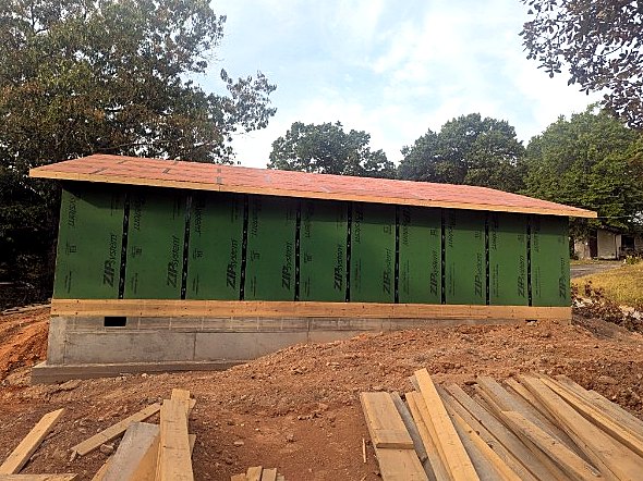 Long side wall sheathed in green ZIP panels